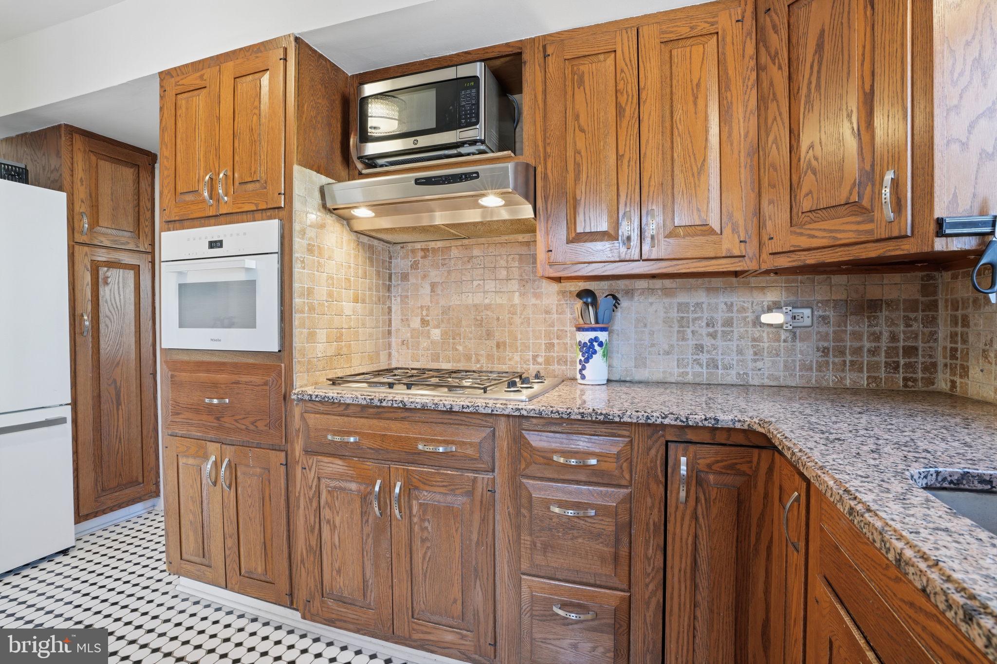 7791 Spring Avenue Elkins Park, PA 19027 - Photo 9 of 33 a kitchen with granite countertop cabinets stainless steel appliances and a counter space