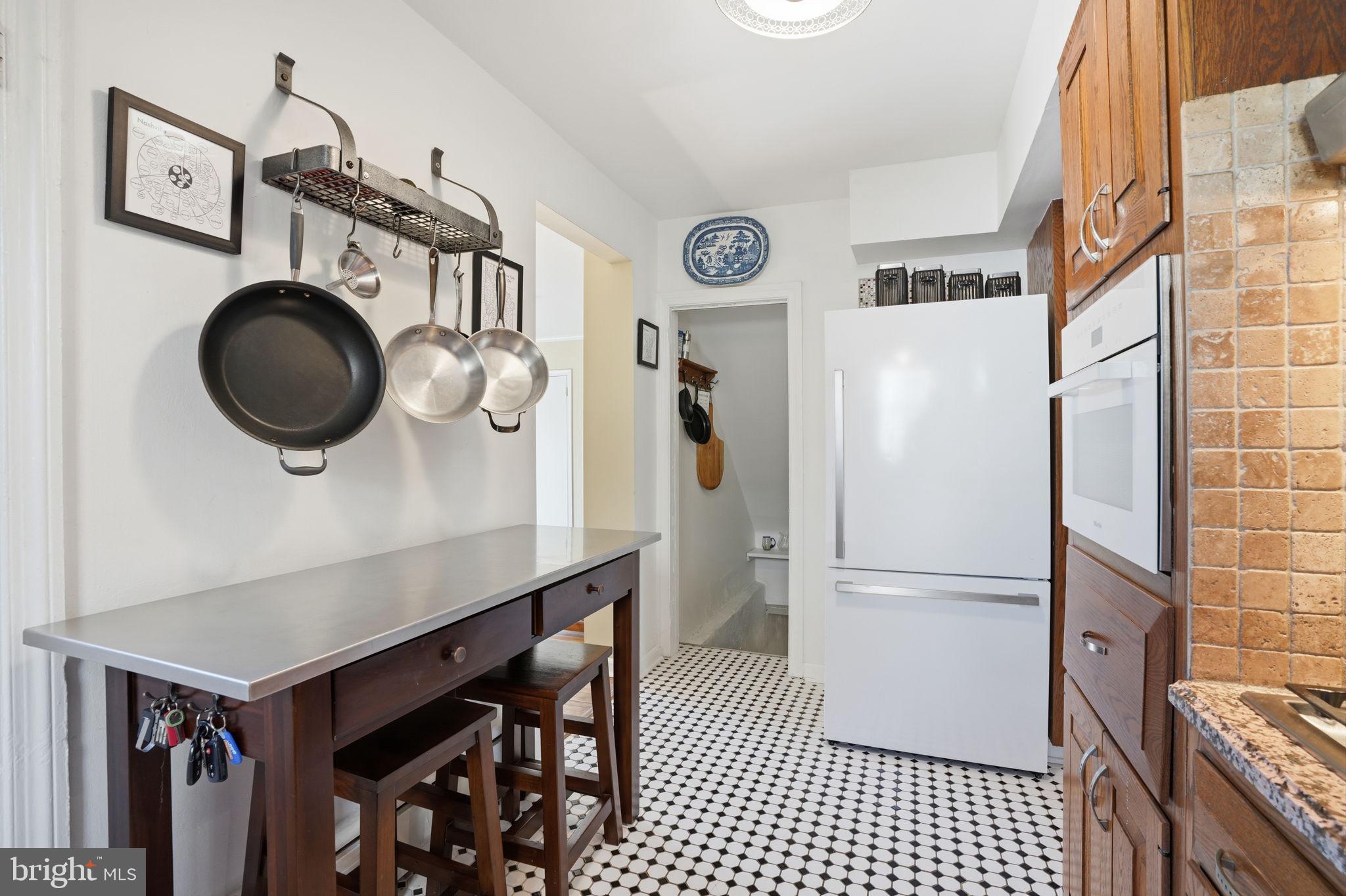 7791 Spring Avenue Elkins Park, PA 19027 - Photo 10 of 33 a kitchen with a refrigerator a sink and cabinets