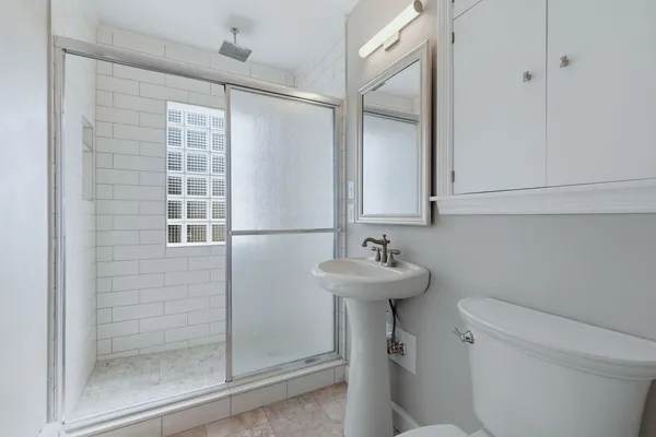 a bathroom with a sink a toilet and shower