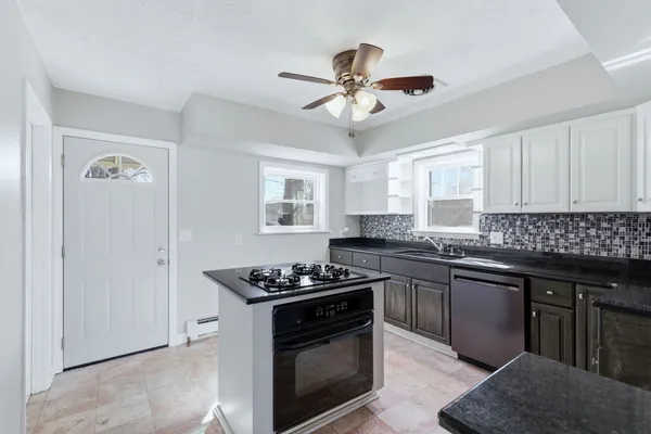 a kitchen with stainless steel appliances granite countertop a sink stove cabinets and refrigerator