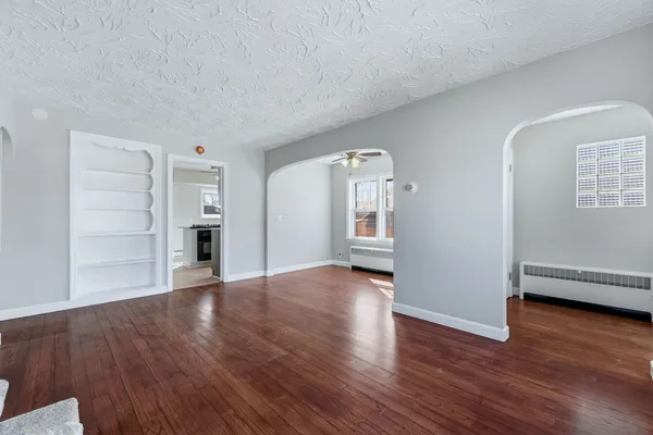 a view of empty room with wooden floor
