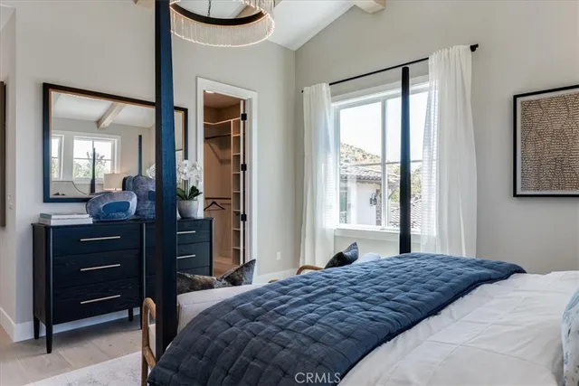 a bedroom with a bed and a mirror on dresser