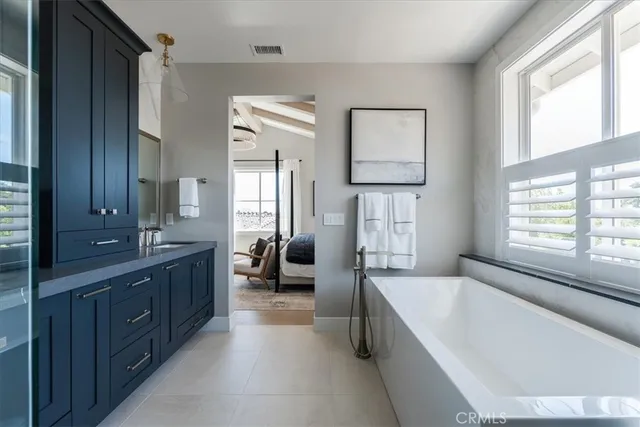 a spacious bathroom with a tub sink and mirror