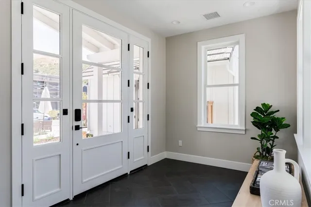 a view of a bedroom with wooden floor and windows