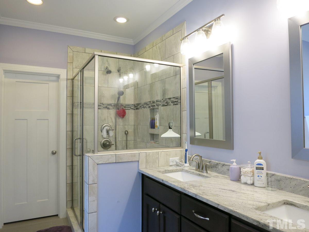 1213 Belhaven Road Cary, NC 27513 - Photo 14 of 25 The Master Bath features wood-look tile flr, jetted tub, lg tiled shower, granite-topped vanity w/double rectangular sinks & private toilet rm.