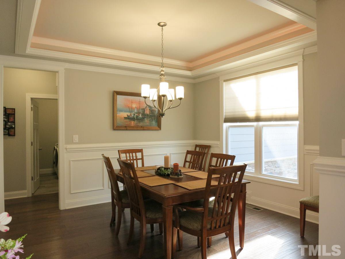 1213 Belhaven Road Cary, NC 27513 - Photo 3 of 25 The spacious & bright formal Dining Rm offers panel wainscot, lighted tray ceiling & brushed nickel light fixture.
