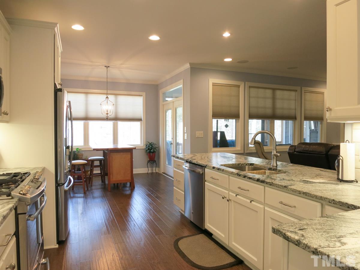1213 Belhaven Road Cary, NC 27513 - Photo 8 of 25 The fabulous Kitchen has lots of tall white custom soft close cabinets w/under cabinet lighting, leather-finish granite ctrs, subway tile backsplash, SS appls (Advantium oven/MW, GE Profile 5-burner gas range, DW), eat-at bar, recessed lighting & pantry.