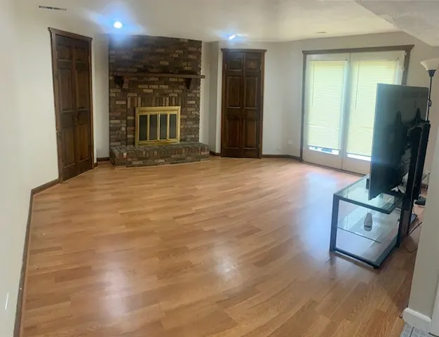 a view of a hallway with wooden floor and glass door