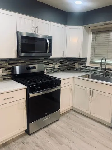 a kitchen with stainless steel appliances granite countertop a stove a sink and a refrigerator