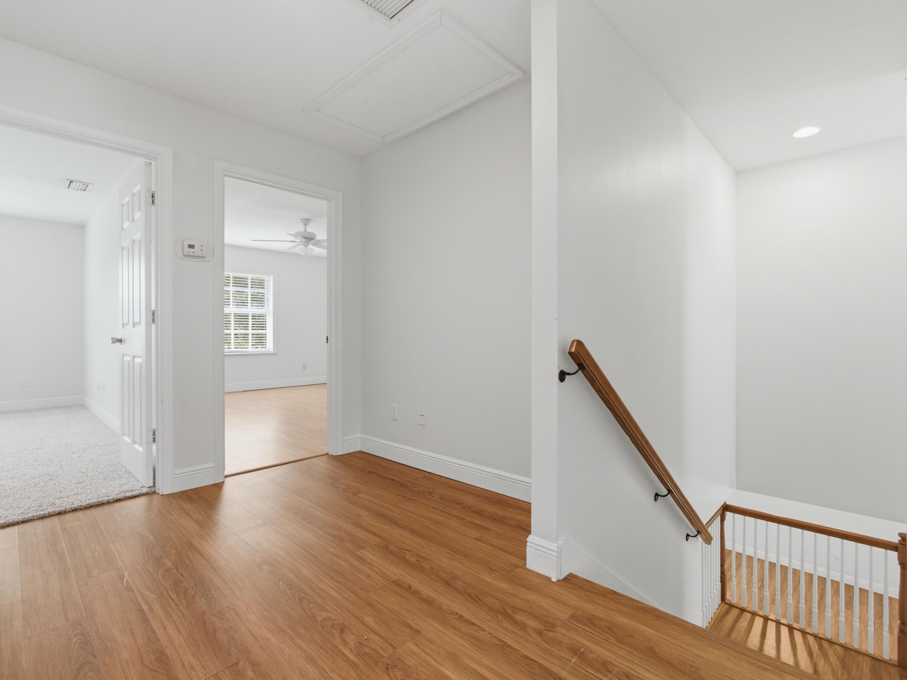 9322 Southeast Athena Street Hobe Sound, FL 33455 - Photo 39 of 69 a view of an empty room with wooden floor and stairs