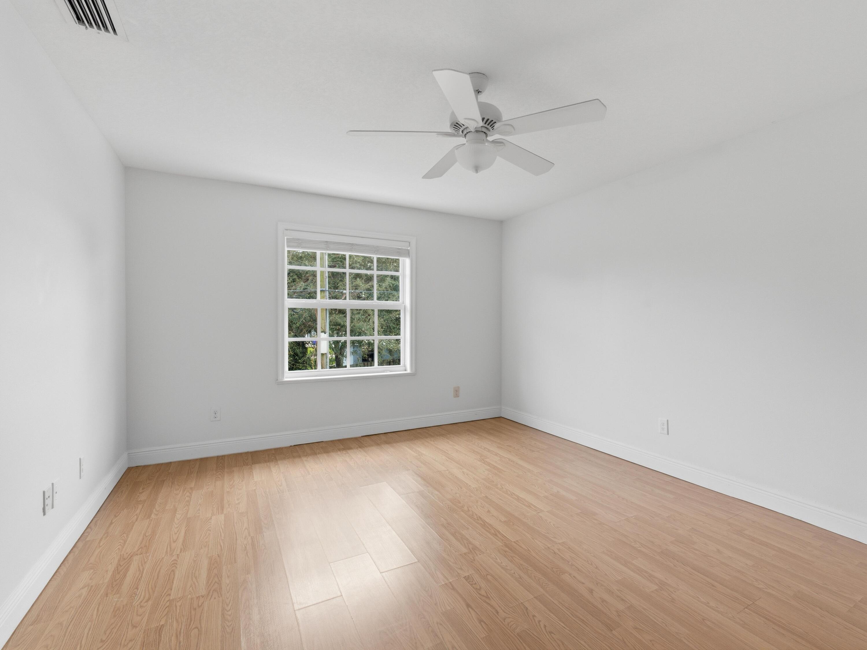 9322 Southeast Athena Street Hobe Sound, FL 33455 - Photo 40 of 69 a view of an empty room with a window and wooden floor