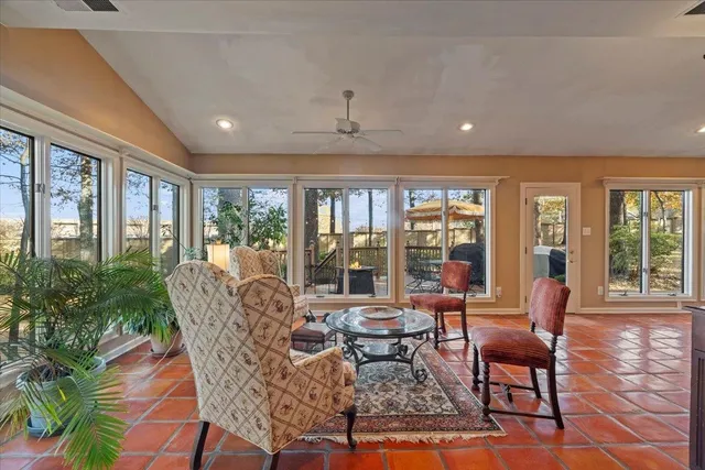 a dining room with furniture large windows and wooden floor