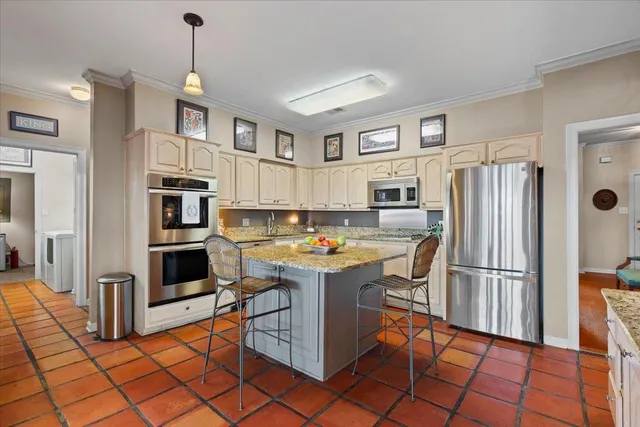 a kitchen with stainless steel appliances granite countertop a refrigerator and a stove