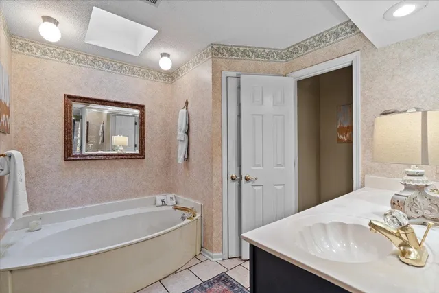 a bathroom with a tub a sink and a mirror