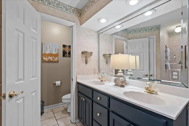 a bathroom with a double vanity sink toilet and mirror
