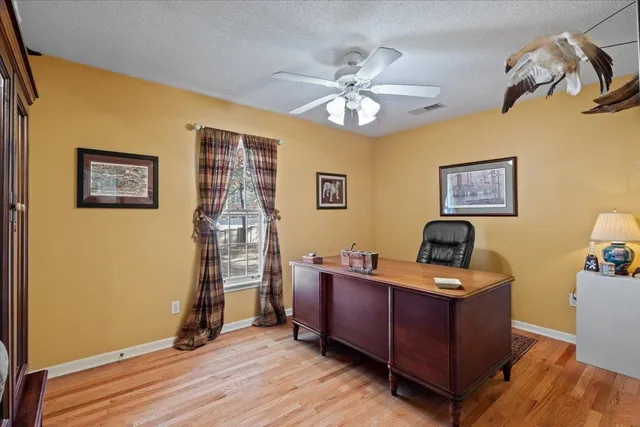 a view of a workspace with furniture and a window