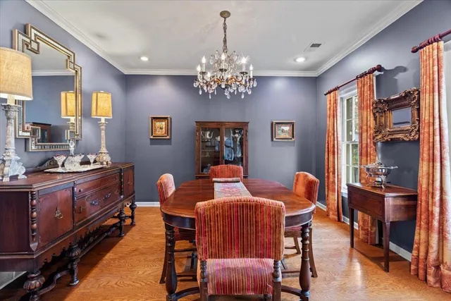 a dining room with furniture chandelier and wooden floor
