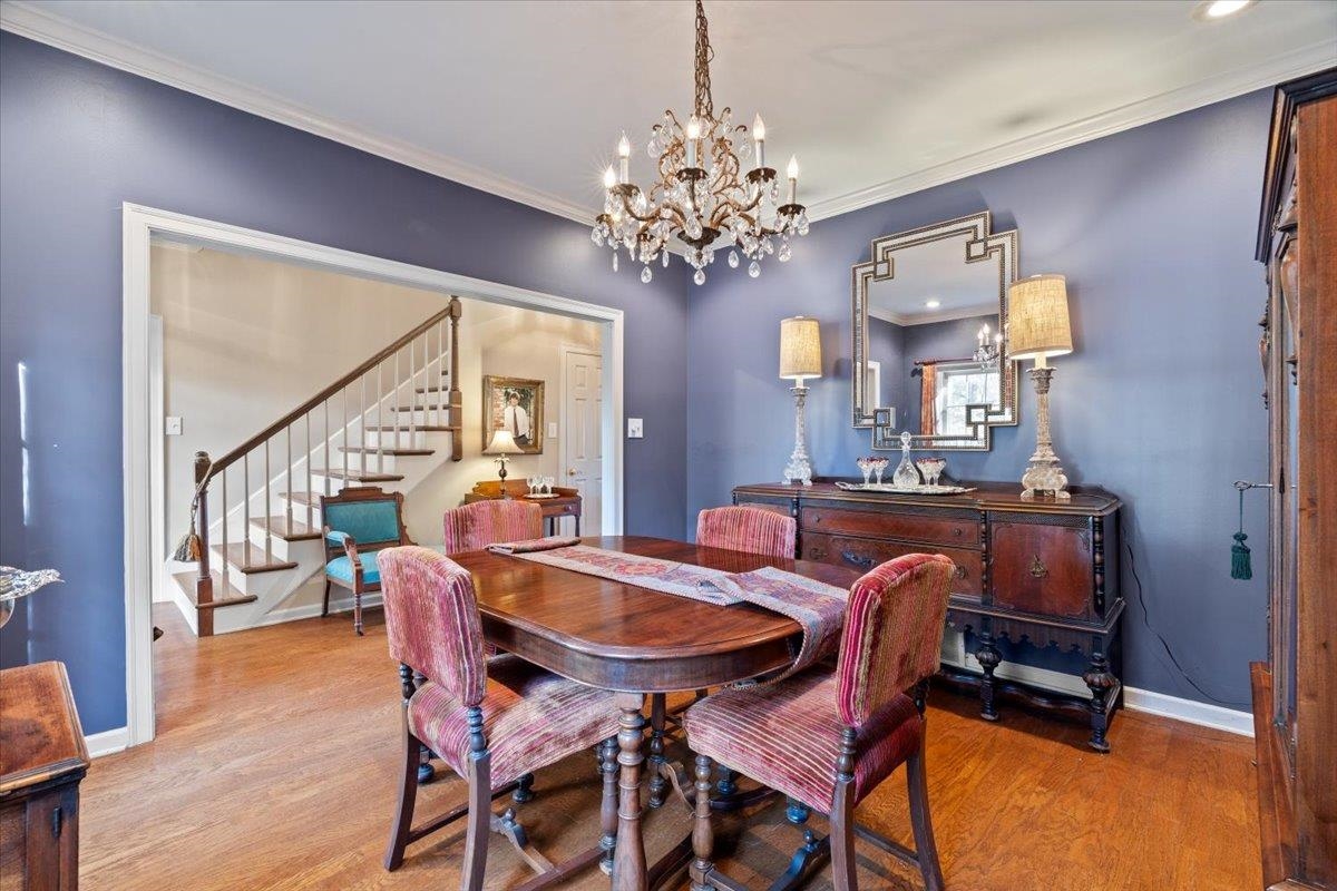 732 North Tree Drive Collierville, TN 38017 - Photo 6 of 40 Dining area featuring ornamental molding, stairs, wood finished floors, and a chandelier