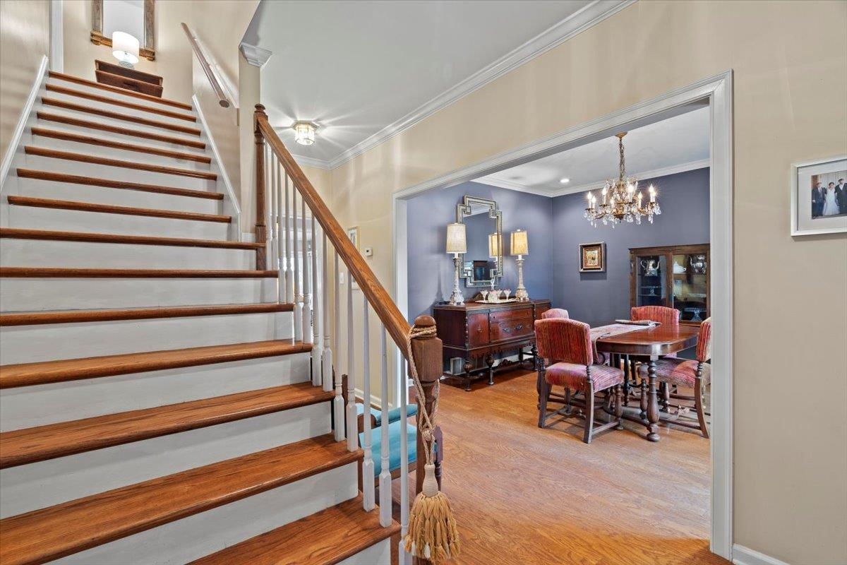 732 North Tree Drive Collierville, TN 38017 - Photo 7 of 40 Stairway with wood finished floors, crown molding, and a chandelier
