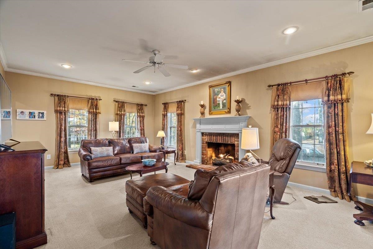 732 North Tree Drive Collierville, TN 38017 - Photo 9 of 40 Carpeted living area featuring crown molding, a brick fireplace, plenty of natural light, ceiling fan, and recessed lighting
