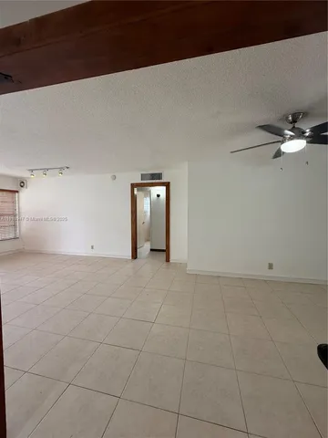 a view of a livingroom with a ceiling fan and window
