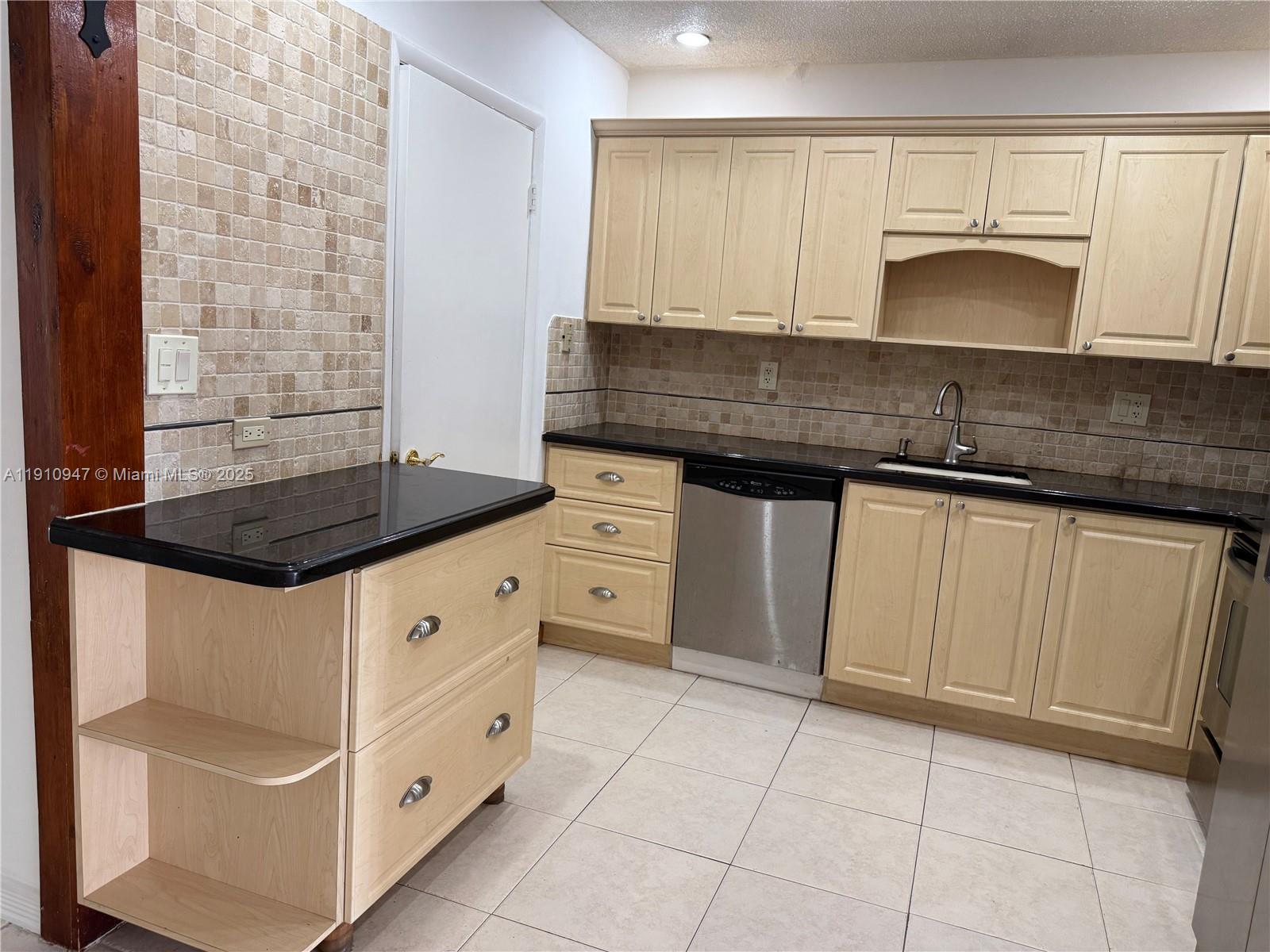12810 Southwest 43rd Drive, Unit 115B Miami, FL 33175 - Photo 3 of 22 a kitchen with granite countertop white cabinets and white appliances