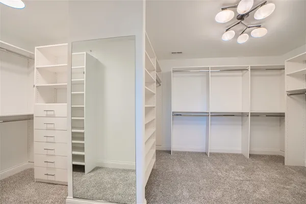 a view of walk in closet with empty racks