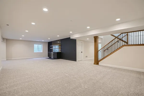 a view of an empty room with window and stairs