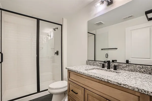 a bathroom with a granite countertop sink toilet and shower