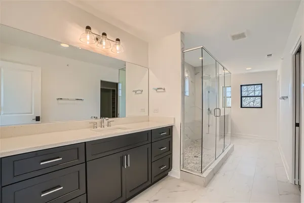 a spacious bathroom with a shower sink double and mirror