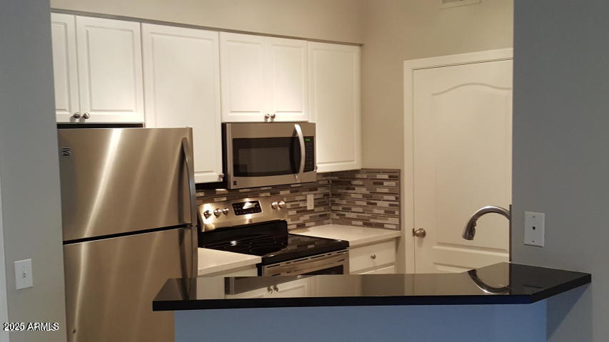 a kitchen with kitchen island a sink appliances and cabinets