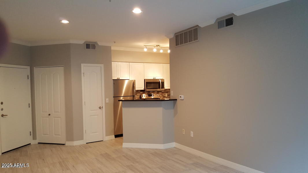 1701 East Colter Street, Unit 153 Phoenix, AZ 85016 - Photo 6 of 11 a view of a kitchen with a fridge and wooden floor