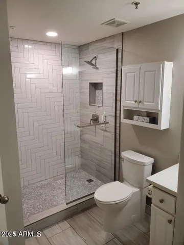 a bathroom with a toilet and a shower