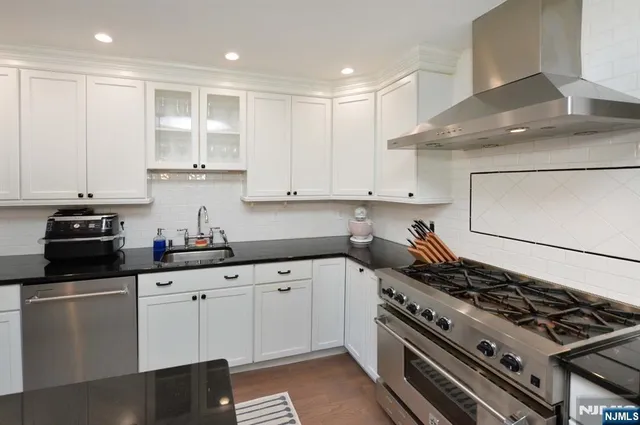 a kitchen with white cabinets and appliances