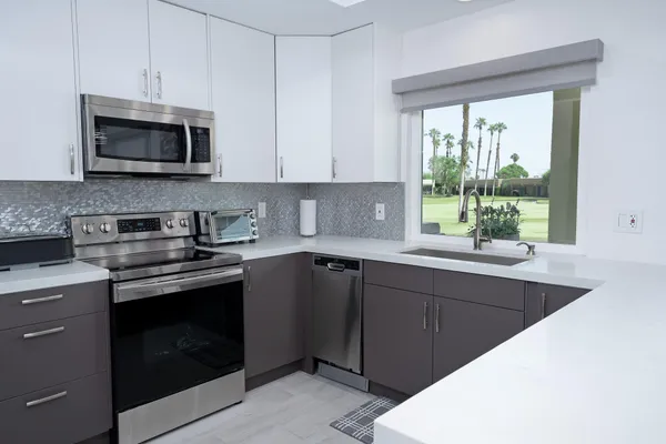 a kitchen with stainless steel appliances a stove sink and microwave