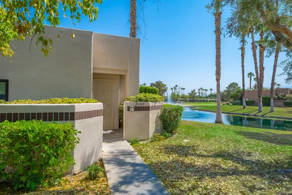 a view of a house with a yard and a fountain