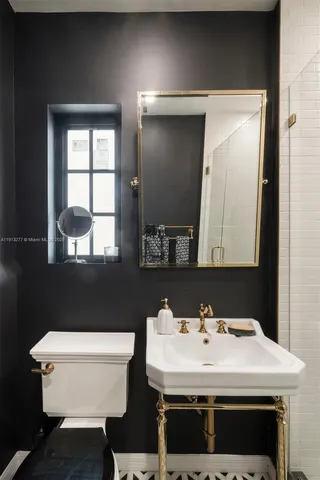 a bathroom with a sink a toilet and a mirror
