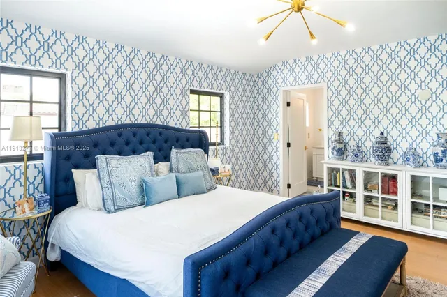 a bedroom with a large bed and a chandelier