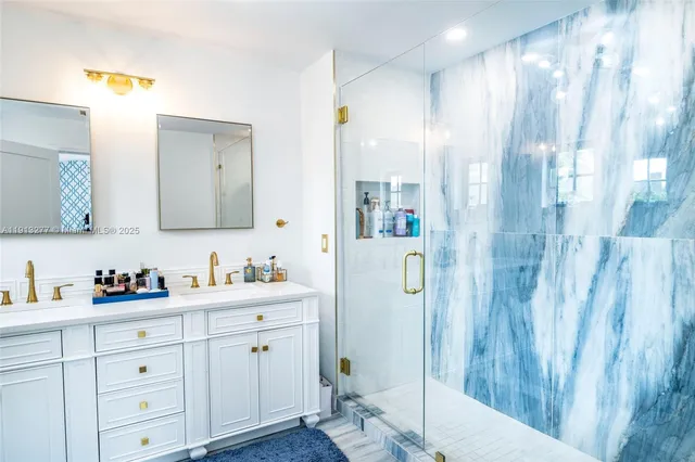 a bathroom with a double vanity sink mirror and shower