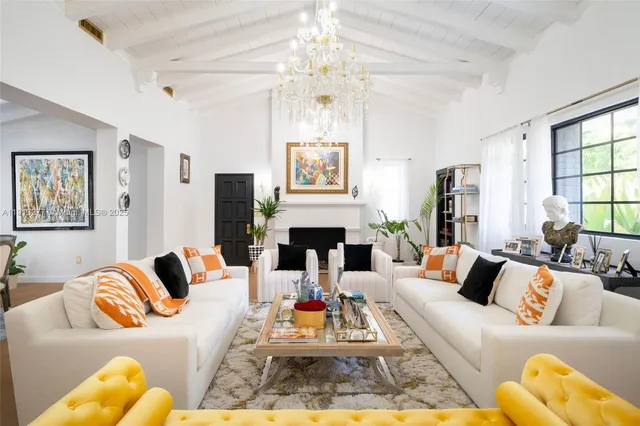 a living room with furniture fireplace and chandelier