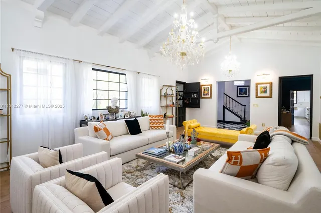 a living room with furniture kitchen view and a large window