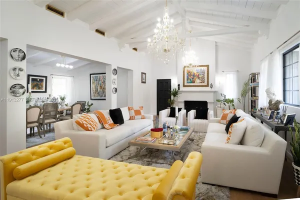 a living room with furniture a fireplace and a chandelier