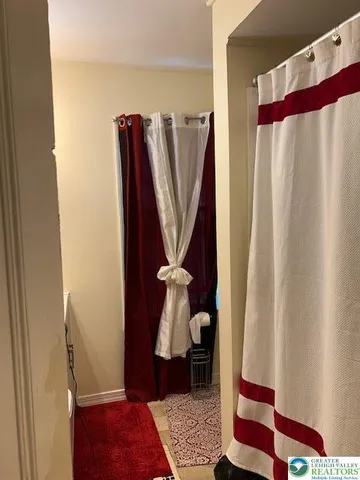 a view of a bedroom with wooden floor and a carpet