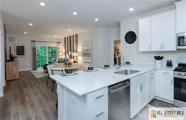 a kitchen with a sink stainless steel appliances and white cabinets