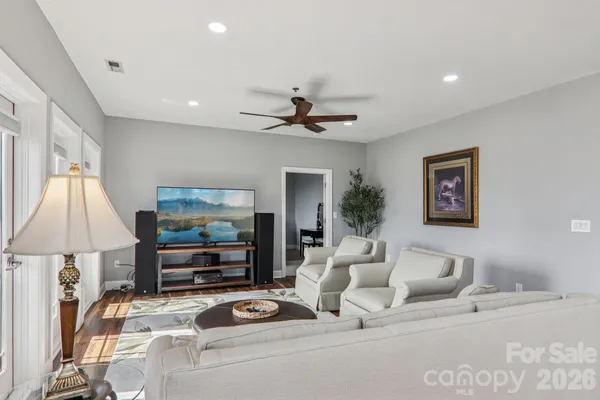 a living room with furniture a lamp and a flat screen tv