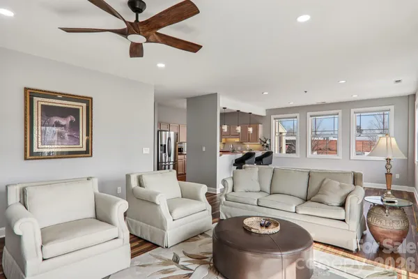 a living room with furniture and a view of kitchen
