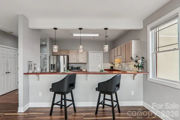 a kitchen with stainless steel appliances kitchen island granite countertop a dining table chairs and sink