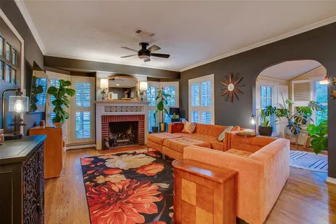 a living room with furniture a fireplace and a potted plant