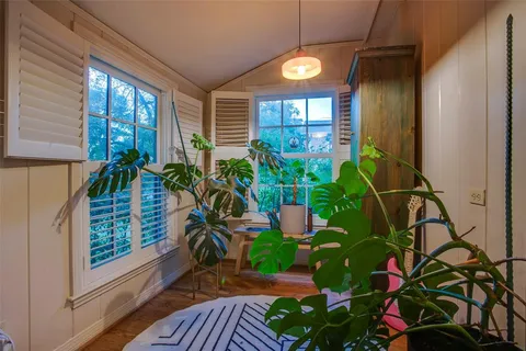 a living room with stainless steel appliances furniture a chandelier and a view of kitchen