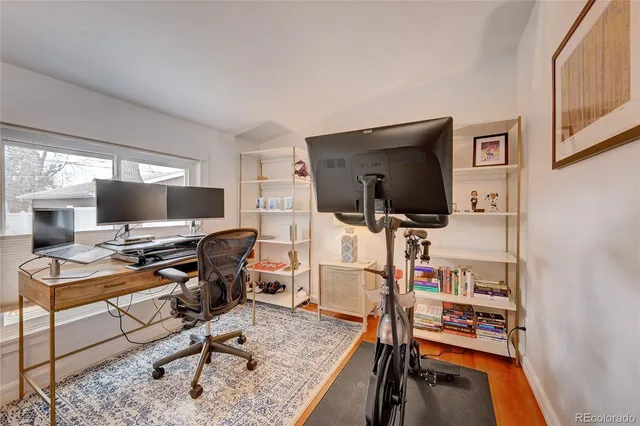 a view of a livingroom with workspace and a flat screen tv